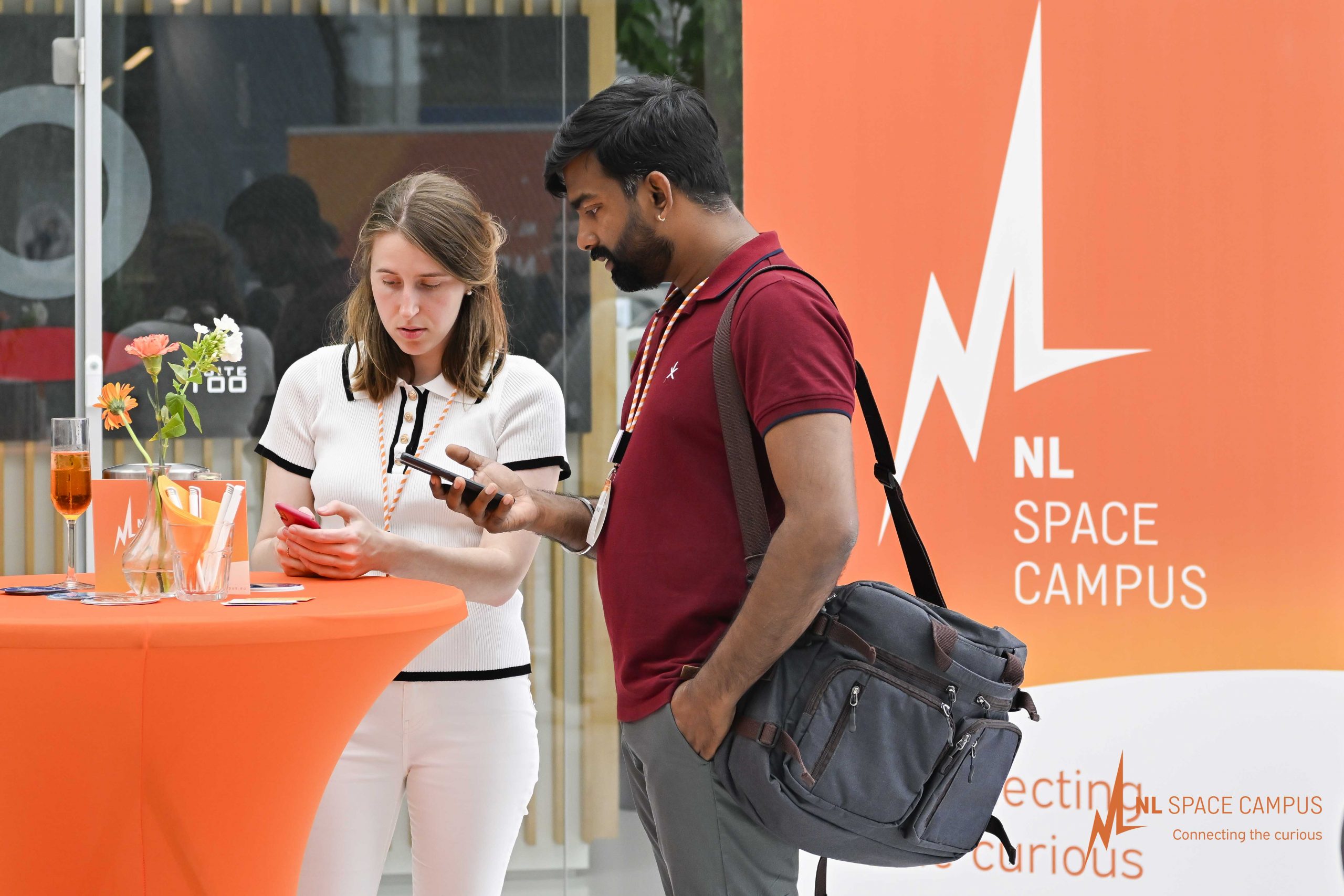 2 personen aan een tafel met mobiele telefoon